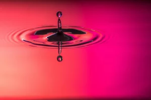 Goccia d'acqua in slow motion nella tonalità magenta